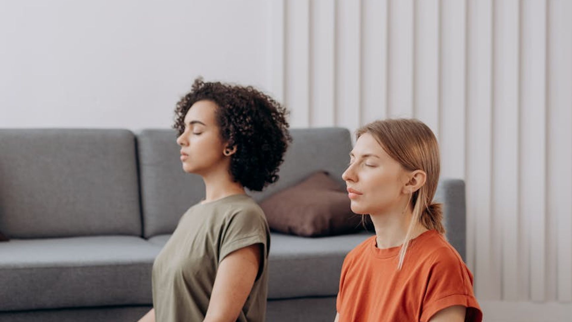 Serene person practicing yoga in a calm, minimalist room at sunrise.